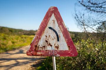 bend in the road sign, old painted red triangle