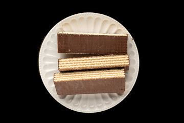 Sweet chocolate wafers cut into pieces, top view, macro.