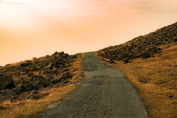 A road with a rocky hillside in the background