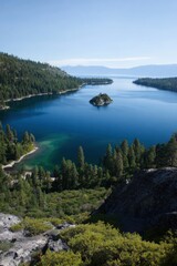 Naklejka premium Stunning aerial view of lake surrounded by pine forest and island on a clear day