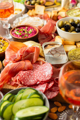 This festive spread features an array of cheese, cured meats, hummus, nuts, and fresh vegetables. Perfect for sharing at a casual get-together or celebration with friends