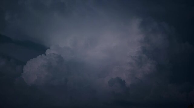 Electric Lightning Cutting Through Storm Clouds. A sharp lightning bolt illuminates dense clouds during a nighttime storm. Sudden light breaks the darkness. Intense weather conditions. 