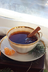 A mug of hot black tea on the windowsill. Christmas atmosphere.