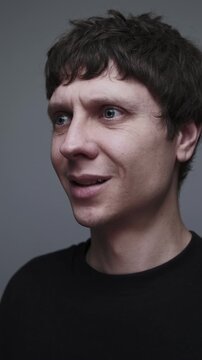 Forced smile that fails. Man lifting eyes and trying to smile while hiding emotional pain. Vertical video