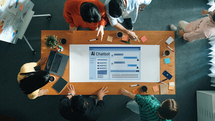 A diverse team gathers around a table to discuss a modern AI chatbot interface, emphasizing collaboration, innovation, and creative problem-solving in a contemporary workspace. Trope