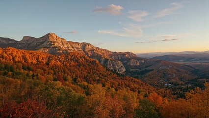 Autumn landscape with mountain ridges and colorful trees during sunset.