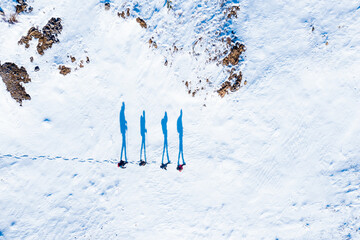 Aerial View of Four Hikers Walking on Snow With Long Shadows in Winter Light