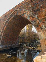 A bridge with a stone archway and a river below