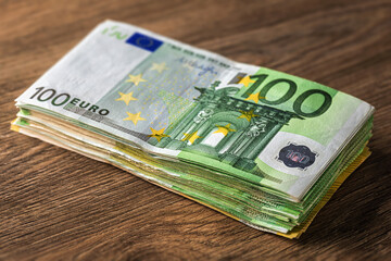 Stack of euro banknotes on wooden table