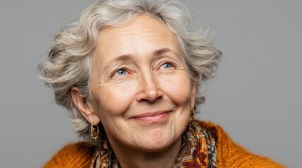 Cheerful senior woman smiles at the camera in a simple setting with soft colors and warm lighting, showing joy in an everyday moment of life