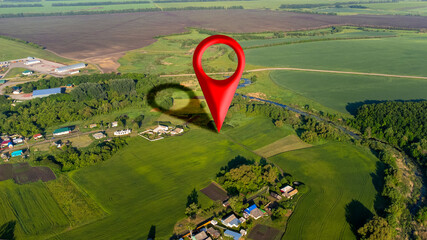 A geographic information point, offering a bird's-eye view of a natural landscape and a small village in the countryside, with location indicated by a geotag. High quality photo