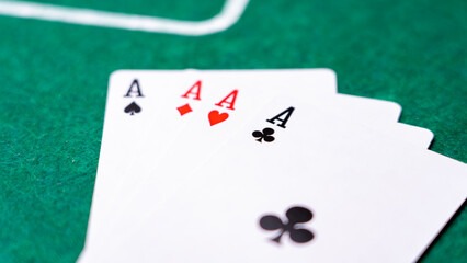 The backdrop of a card game, featuring four exposed aces on the table and betting chips. The perspective is from above. High quality photo