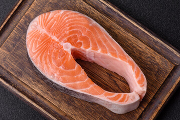 Fish, raw salmon steak, fresh seafood for grilling with salt, spices, and herbs. Raw salmon steak