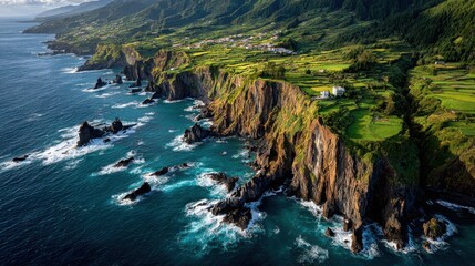 Rugged cliffs and cultivated fields meet the turbulent ocean in Santa Barbara, Azores, Portugal captured from above