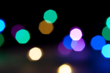 Soft, multicolored bokeh lights glowing against a dark background, creating a dreamy festive atmosphere.
