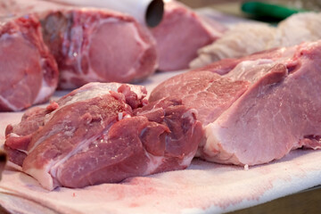 Fresh cuts of meat displayed on a butcher's counter for sale