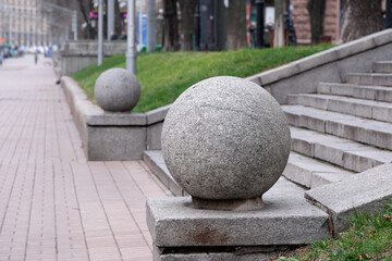 Smooth stone spheres adorn urban steps in a tranquil park setting