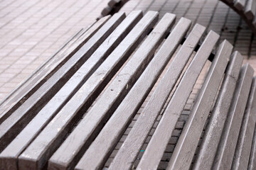 Wooden benches glisten in the soft light of an urban plaza