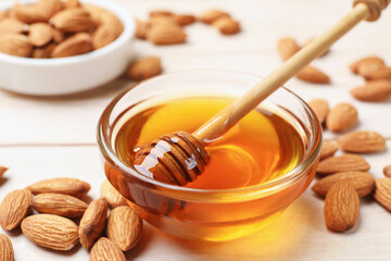 Honey with almond nuts and dipper on wooden table, closeup