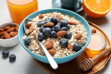Dry oat flakes, nuts and blueberries on grey table for breakfast, closeup