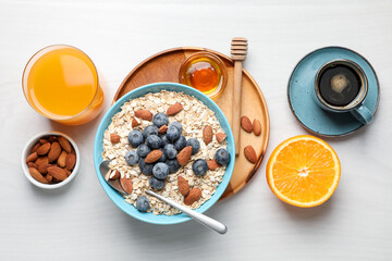 Dry oat flakes, nuts and blueberries served on grey wooden table for breakfast, flat lay