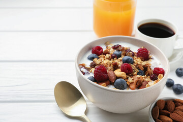 Healthy breakfast. Oatmeal with nuts, berries and milk on white wooden table, closeup. Space for text