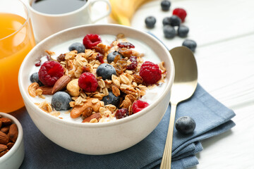 Healthy breakfast. Oatmeal with nuts, berries and milk on white wooden table, closeup