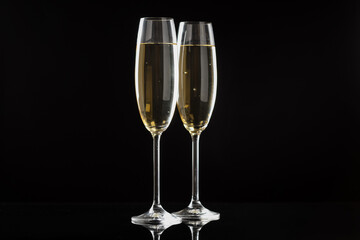 Flute glasses with sparkling wine on black background. Merry Christmas and Happy New Year