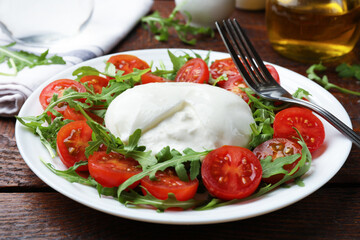 Delicious burrata cheese with arugula and tomatoes on wooden table, closeup