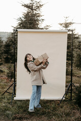 M&auml;dchen, 11, mit Weihnachtsgeschenk vor beigem Studiohintergrund in der Natur