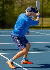 Senior finishes hitting a topspin forehand in a pickleball tournament1