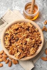 Tasty granola with dried fruits and honey on light grey table, flat lay