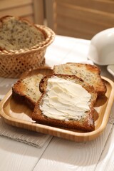 Bread slices with butter on white wooden table, closeup