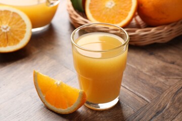 Fresh orange juice and fruits on wooden table, closeup
