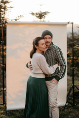 Paar vor einem beigen Studiohintergrund in freier Natur