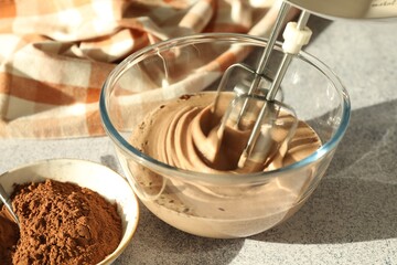 Mixing chocolate dough at grey textured table, closeup