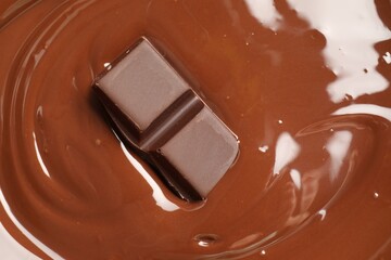 Tasty melted chocolate and piece as background, top view