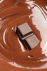 Tasty melted chocolate and piece as background, closeup