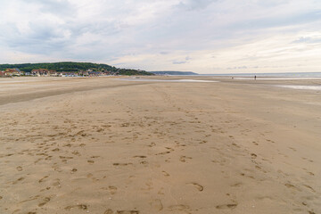 Deserted ocean beach in the town of Deauville in Normandy, France Time, evening clouds, low and sparse. Houses on the coast are slightly visible