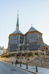 An ancient wooden church Eglise sainte Catherine with 2 buildings in Honfleur Normandy France. The photo was taken in the evening