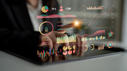 A woman interacts with a tablet displaying various charts and graphs in a bright business setting, showcasing the importance of data analysis and technology. Impute