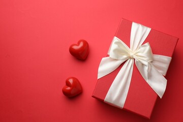 Beautiful gift and decorative hearts on red background, flat lay with space for text. Saint Valentine's day