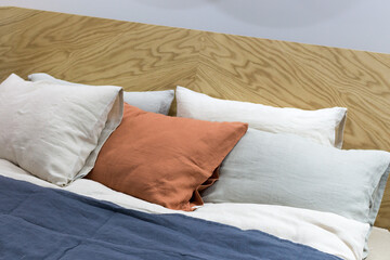 Decorative pillows on the bed close-up. A beautiful combination of natural fabrics, close-up