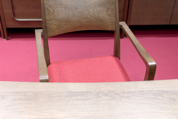 Wooden desk and chair with red seat on the red floor in the living room, close-up