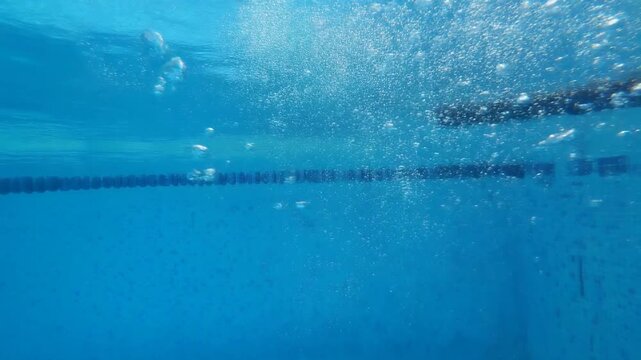 4K Cinematic slow-motion underwater footage. Lots of air bubbles float in the blue water 