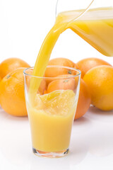 Fresh Orange Juice Pour with Whole Oranges and Citrus Slice