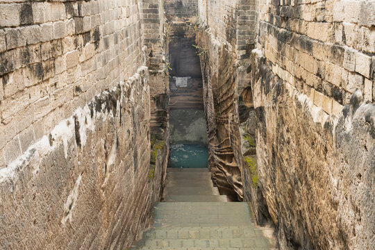 Navghan Kuvo, the ancient rock-cut stepwell in Uparkot Fort, Junagadh, India known for its deep, narrow stairway and historic architecture.