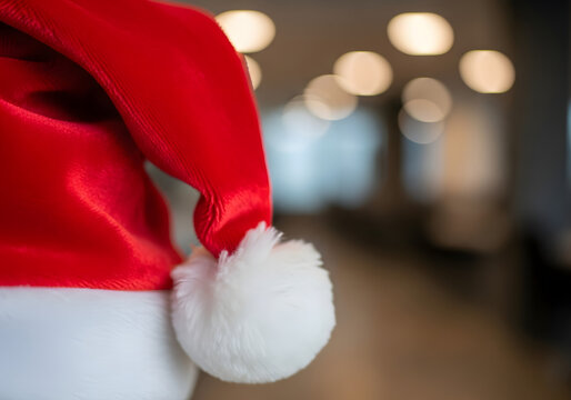 Gorro navide&ntilde;o de Pap&aacute; Noel en primer plano con fondo desenfocado de luces, concepto de compras, retail y promociones