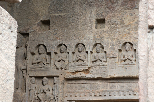 Intricate Buddhist rock-cut reliefs at Kanheri Caves, Mumbai. Featuring serene seated Buddha figures in meditative poses carved into ancient basalt stone walls. Historic Indian heritage site.