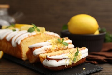 Delicious lemon cake with glaze, fresh fruit slices and mint on table, closeup